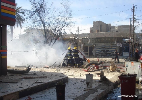 &nbsp;Iraqi firefighters work at the site of a car bomb attack at Karada district in Baghdad, Iraq, March 19, 2013. At least 48 people were killed and 167 others wounded in a series of bombings and shootings in the Iraqi capital of Baghdad on Tuesday, an Interior Ministry source said. (Xinhua/Bashar)