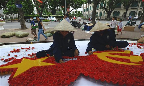 Workers prepare a flower display marking the upcoming Independence Day on September 2, in downtown Hanoi on Monday. Vietnam is to mark next week its 67th anniversary of National Day. Photo: AFP 
