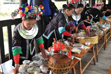 Women of the Dong ethnic group prepare a feast on the Chengyang Fengyu Bridge during a celebration ceremony marking the 100th anniversary of the completion of Chengyang Fengshui Bridge held in Sanjiang Dong Autonomous county, South China's Guangxi Zhuang Autonomous Region, December 1, 2012. Built in 1912, the 77.76-meter-long bridge is famed for its combination of bridge, veranda and Chinese pavilion. (Xinhua/Lai Liusheng) 