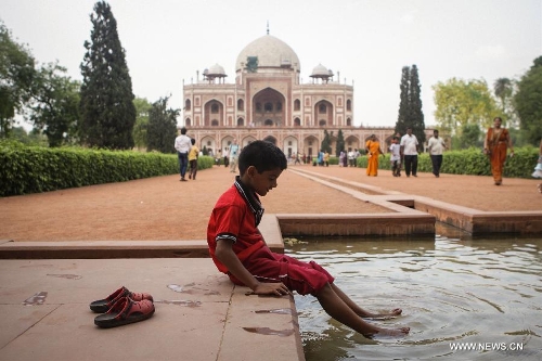 A boy plays in the pool at Humayun's Tomb in New Delhi, capital of India, May 12, 2013. Humayun's Tomb, located in east New Delhi, was built in 1569 to 1570 by Humayun's widow. As a precursor to the Taj Mahal, it stands on a platform of 12,000 square meters and reaches a height of 47 meters. The earliest example of the Persian influence in Indian architecture, the tomb itself is in the center of a large garden, surrounded by 12 hectares of gardens with pools joined by channels. The tomb brought Persian style to Delhi, but the two-tone combination of red sandstone and white marble is local, which shows the merging of different cultures. Humayun's Tomb was inscribed on the World Heritage List by the United Nations Educational, Scientific and Cultural Organization in 1993. (Xinhua/Zheng Huansong) 