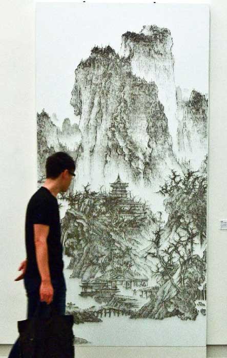 A visitor watches Taiwanese artist Chen Chun-Hao's nail drawing work Buddhist Temple in Mountain at Kuandu Museum of Fine Arts in Taipei, southeast China's Taiwan, July 20, 2012. Photo: Xinhua