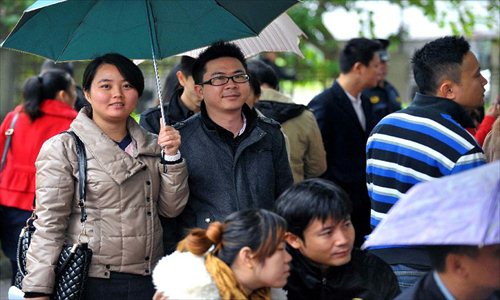 Couples wait in rain to register in front of the marriage registration office in Haikou, capital of South China's Hainan Province, January 4, 2013. Quite a number of couples flocked to tie the knot on January 4, 2013, or 2013/1/4, which sounds like 