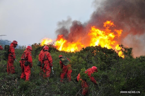Forest policemen try to put out a forest fire in Anning, southwest China's Yunnan Province, April 9, 2013. The fire broke out around 1 p.m. (0500 GMT) in Anning City. Forest policemen and firefighters have been mobilized to quench the fire. (Xinhua/Zhong Yaojun) 