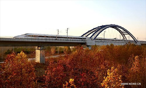 A train runs through the Yellow River Rail-Road Bridge in Zhengzhou City, capital of central China's Henan Province, November 25, 2012. The high-speed rail route from Beijing to the southern Chinese city of Guangzhou will open next month, cutting the 2,200-km journey time by 14 hours, according to the Ministry of Railways. A trial operation along the Beijing-Zhengzhou section, the last part of the route, began on Sunday morning. Photo: Xinhua