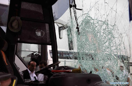 People check outside a destroyed bus at the parking area of the Sinan Erdem Arena in Istanbul, Sunday, May 13, 2012. About 300 Panathinaikos' basketball fans attacked the buses with Olympiakos' supporters. Photo: Xinhua