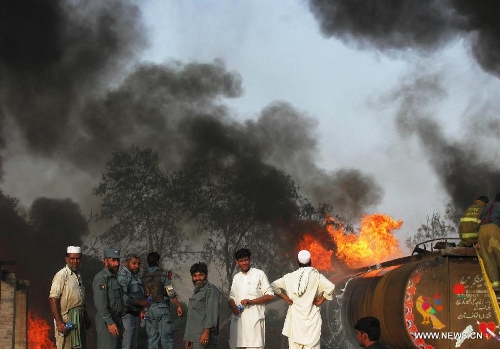 Firefighters work to extinguish fire at a parking lot where five oil trucks caught fire in Jalalabad, capital city of eastern Afghan province of Nangarhar on May 20, 2013. At least one person was killed in the fire on Monday afternoon. Police officials ruled out involvement of militants in the incident. (Xinhua/Tahir Safi) 