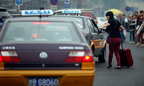 A woman hails a taxi in Beijing Wednesday. Photo: CFP
