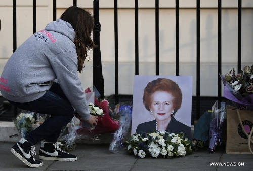 A person lays flowers outside the residence of Baroness Thatcher at the Chester Square in London, Britain, on April 8, 2013. It has been confirmed that Lady Thatcher died this morning following a stroke at the age of 87. (Xinhua/Wang Lili) 