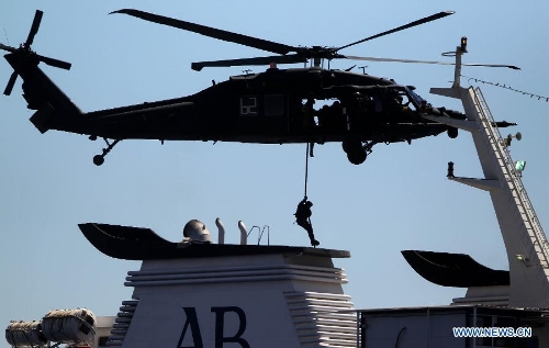 A special operations soldier, one of a contingent from Iraq, Jordan and the U.S., rappels from a rope to board a ship during a vessel board search and seizure exercise as part of Eager Lion multinational military maneuvers, in the Gulf of Aqaba, Jordan, Wednesday, June, 19, 2013. The 12-day exercise involves combined air, land and sea maneuvers accross Jordan. Along wih Jordan and the U.S., the exercise brings together some 8,000 personnel from 19 Arab and European nations to train on border security, irregular warfare, anti-terrorism and counterinsurgency. (Xinhua/Mohammad Abu Ghosh) 