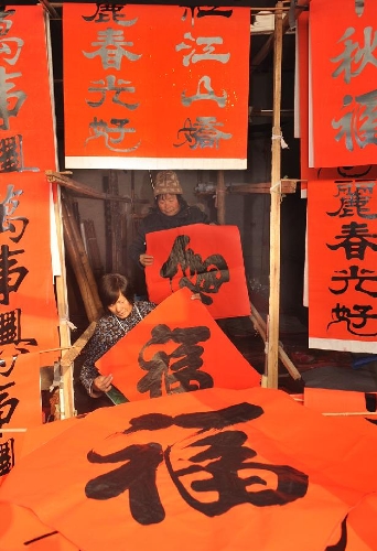Villagers try to hang red paper on which Chinese character 