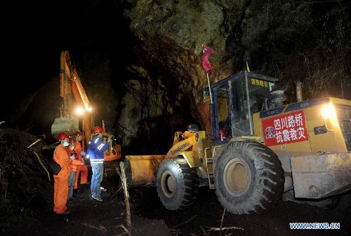 Workers of Sichuan Road and Bridge (Group) and China Railway Group rush to repair the only road heading to Lingguan Township of Baoxing County, which was badly hit by the earthquake, in Lushan County of Ya'an City, southwest China's Sichuan Province, at the midnight of April 21, 2013. A 7.0-magnitude earthquake jolted Lushan County on April 20 morning, seriously affecting the transportation from Lushan to Baoxing. (Xinhua/Luo Xiaoguang)  