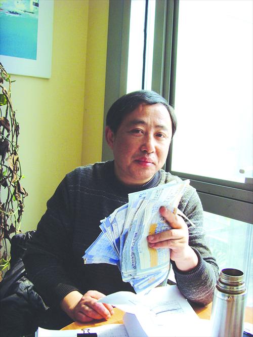Li Long holds the receipts he received from a delivery service after sending evidence and letters to local courts regarding his case on Tuesday in Beijing. Photo: Liu Linlin/GT