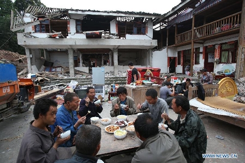 Displaced villagers have a meal together in Gucheng Village, Longmen Town, Lushan County, southwest China's Sichuan Province, April 21, 2013. Military and civilian rescue teams are struggling to reach every household in Lushan and neighboring counties of southwest China's Sichuan Province, badly hit by Saturday's strong earthquake. (Xinhua/Jin Liwang) 