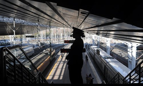 A woman in a railway staff uniform stands on a stairway at the Beijing West Railway Station. Photo: Wu Gang/GT