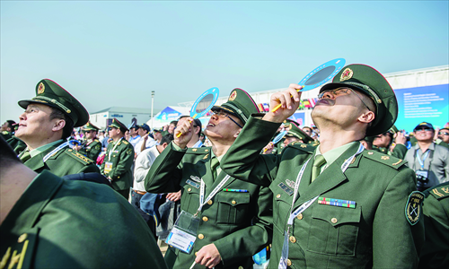 Officers from the People's Liberation Army watch planes performing during the 9th China International Aviation and Aerospace Exhibition in Zhuhai on Tuesday. The Airshow comes as the Communist Party of China holds a meeting to elect the country's new leaders. Photo: AFP