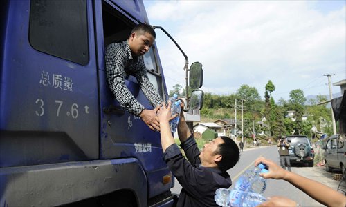 Local villagers give out water to quake-relief volunteers in Miaoxi village, Lushan county, Sichuan Province on April 24. Photo: Li Hao/GT