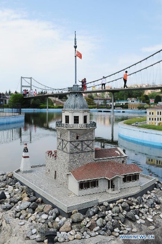 Visitors walk through the Bosphorus Bridge which standing behind the miniature of Maiden's Tower in the Miniature park in Istanbul, Turkey, on May 11, 2013. The Miniaturk park is the first miniature park in Istanbul and has welcomed 6.5 million visitors over the past 10 years. (Xinhua/Lu Zhe) 