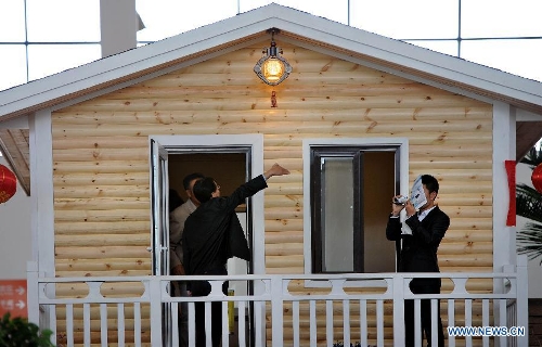 People visit an energy-saving cabin during the 2013 China (Shenyang) International Architecture Exposition in Shenyang, capital of northeast China's Liaoning Province, May 20, 2013. The three-day expo kicked off on Monday, with 615 enterprises from home and abroad participated. (Xinhua/Yao Jianfeng)