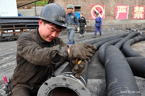 &nbsp;A miner binds a ventilating duct before conveying rescue materials to the coalmine in which a coal and gas outburst has left two people dead at the Jinjia Coal Mine under the Panjiang Investment Holding Group in Liupanshui City, southwest China's Guizhou Province, Jan. 20, 2013. Rescuers have been working for 42 hours until 1 p.m. on Jan. 20, but they failed to find the trapped miners. (Xinhua/Yang Ying)