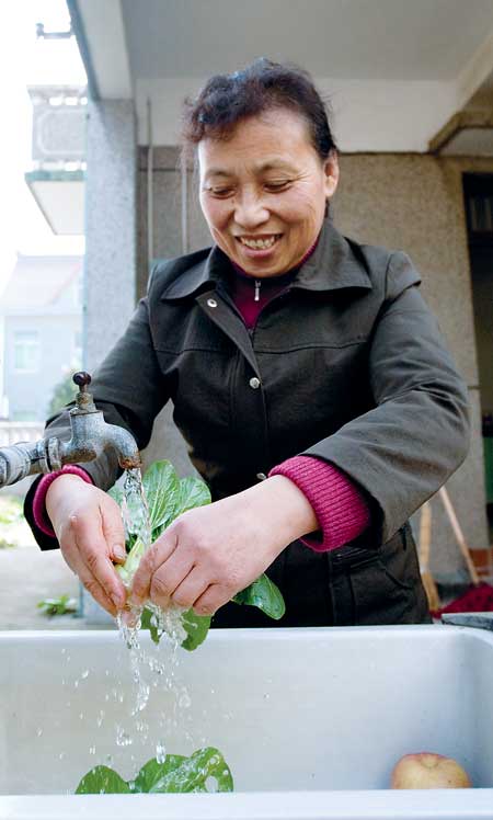 A resident in Pudong New Area pours tap water from the Qingcaosha reservoir.