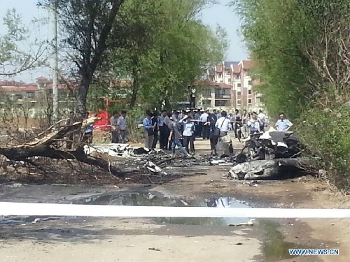 Photo taken on May 16, 2013 with a cellphone shows the site where a light plane failed to take off and crashed at Taoxian Airport in Shenyang, capital of northeast China's Liaoning Province. Three people on board were injured in the accident on Thursday. (Xinhua)