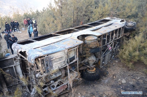 Photo taken on Feb. 2, 2013 shows the damaged bus after an accident occured in Ningxian County of Qingyang city, in northwest China's Gansu Province. The death toll has risen to 13 as the rescuers found another five corpses at the accident site on Saturday morning. A bus tumbled into a ravine and caught fire on Friday night here in Gansu Province. (Xinhua)
