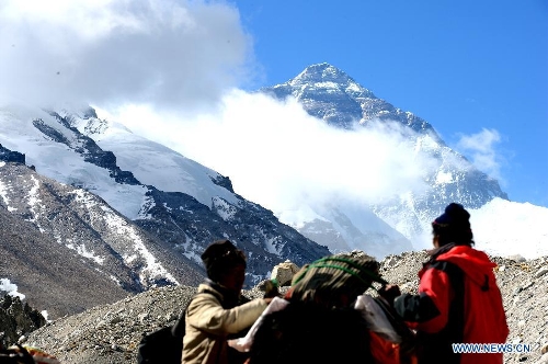 Workers tie materials onto the back of a yak on Mount Qomolangma (Mount Everest), southwest China's Tibet Autonomous Region, May 19, 2013. Xia Jianfeng, a member of a commercial climbing team who suffered from cerebral edema on the altitude of 8, 650 meters, was rescued to the base camp on May 19. The successful rescue made a miracle as it took place in such high altitude of the mountain. As increasingly more people come to climb the world's highest mountain in recent years, the rescue system here is also rapidly improved for the safety of climbers.(Xinhua/Chen Tianhu)