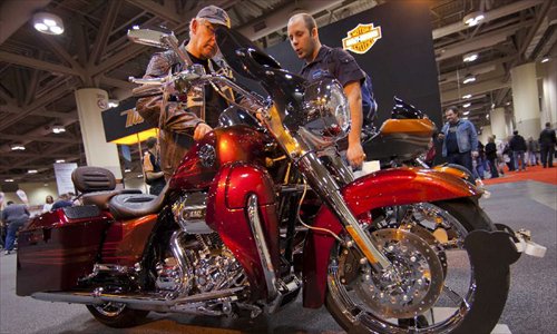 Visitors watch a displayed motorcycle during the 2012 Toronto Motorcycle Show at the Metro Toronto Convention Centre in Toronto, Canada, December 8, 2012. The three-day event displays hundreds of new 2013 motorcycles, scooters from the world's top manufacturers from December 7 to 9 this year. Photo: Xinhua