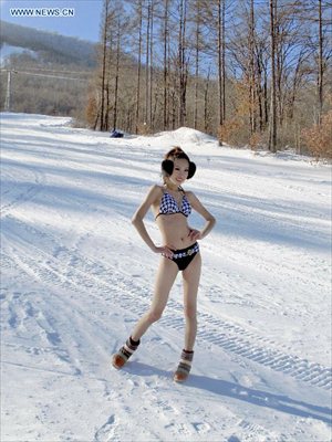 A model presents bikini collections during a ski performance held in Beidahu ski resort of Jilin City, northeast China's Jilin Province, December 31, 2012. Some 40 models in G-strings and bras shivered from the cold as they showed off on snow-covered slopes in the ski resort to promote the event. Photo: Xinhua 

