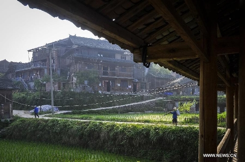 People walk on a pathway in Dimen Dong minority village in Liping County of southwest China's Guizhou Province, June 21, 2013. Dimen is a Dong minority village with about 2,500 villagers. It is protected properly and all the villagers could enjoy their peaceful and quiet rural life as they did in the past over 700 years. (Xinhua/Ou Dongqu)