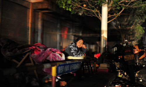 An earthquake victim rests at the roadside of Lushan county on April 21. A 7.0-magnitude earthquake hit Lushan county on the morning of April 20. Longmen, Baosheng and Taiping townships were the worst hit areas. Victims spent their first night after the quake in temporary tents along the roadside. Photo: Xiao Jiuyi/Xinhua
