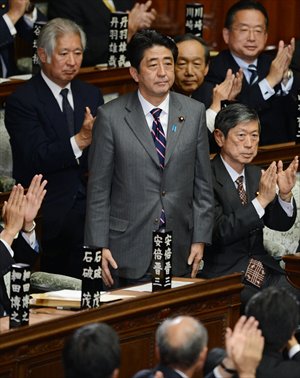 Shinzo Abe (center) is applauded by parliament members after he was elected as Japan's prime minister by the lower house of parliament in Tokyo on Wednesday. Photo: AFP