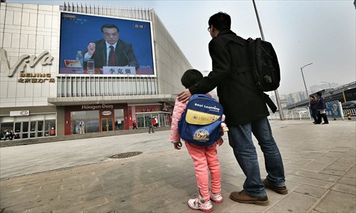 Residents in Beijing watch newly-elected premier Li Keqiang answer questions raised by Chinese and overseas media on an outdoor TV screen. The first session of the 12th National People's Congress closed Sunday, Li met the press for the first time as the nation's premier, vowing to push forward reforms despite obstacles. Photo: CFP
. Photo: AFP