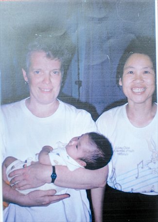 Margaret picking up baby Jenna. Photo: courtesy of Jingchu Love Alliance  