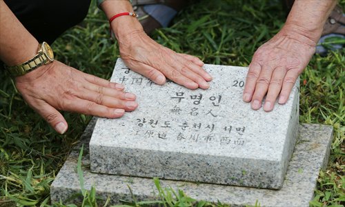 Chinese veterans who fought in the Korean War (1950-53) caress a tombstone of unknown Chinese officers at the graveyard in Paju, South Korea, on July 9. Photo: CFP