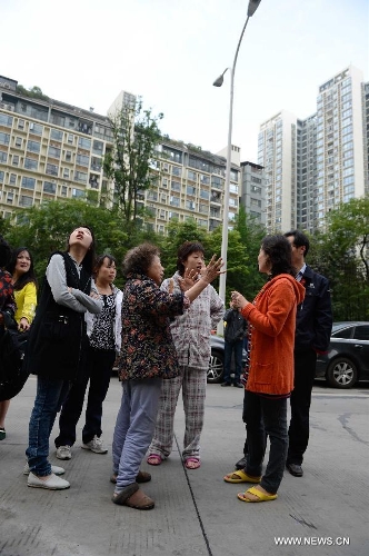 Citizens gather outside their apartments to avoid aftershocks of a quake, in Chengdu, capital of southwest China's Sichuan Province, April 20, 2013. A 7.0-magnitude earthquake hit Lushan County of Sichuan Province at 8:02 a.m. Beijing Time (0002 GMT) on Saturday, according to the China Earthquake Networks Center (CENC). The epicenter, with a depth of 13 kilometers, was monitored at 30.3 degrees north latitude and 103.0 degrees east longitude. Residents in Chengdu felt the earthquake. (Xinhua/Li Qiaoqiao)