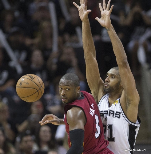 San Antonio Spurs' Tim Duncan (R) vies with Miami Heat's Dwyane Wade during their Game 3 of the 2013 NBA Finals in San Antonio, Texas, the United States, June 11, 2013. San Antonio Spurs won 113-77. (Xinhua/Yang Lei)