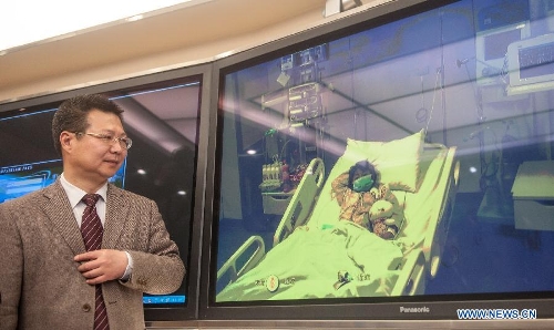 Cheng Jun, a spokesman with the Beijing Ditan Hospital, introduces the situation of a seven-year-old girl, who was infected with the H7N9 strain of bird flu, beside a screen showing the girl receiving medical treatment in the hospital in Beijing, capital of China, April 13, 2013. This was the first such case in the Chinese capital. The child is in stable condition. Two people who have had close contact with the child have not shown any flu symptoms, and the girl's parents were engaged in live poultry trading in a township of Shunyi District in Beijing's northeastern suburbs. (Xinhua/Zhang Yu) 
