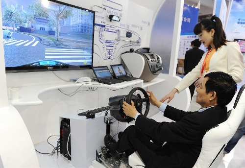 A visitor experiences the driving simulation system during the China (Shanghai) International Technology Fair in Shanghai, east China, May 8, 2013. (Xinhua/Lai Xinlin) 