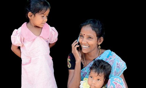 An indian woman speaks on her mobile phone in a slum area on the banks of the heavily polluted Cooum river in Chennai, India, on March 14 2012. Photo: CFP