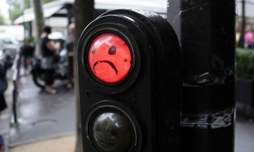 A picture taken on June 26, 2012 shows a graffiti depicting a smiley face on a red traffic light in Paris. Photo:ImagineChina