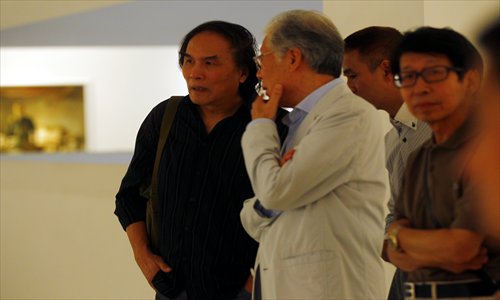 Xia Baoyuan (left) talks to visitors to his exhibition.