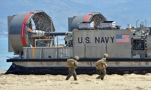 US soldiers walk past a US Navy landing craft air cushion at a beach during the Combined Joint Logistics Over the Shore exercise in Pohang, 260 kilometers southeast of Seoul, on Monday. The wait for North Korea's expected missile test may stretch to July, the South's defense ministry said Monday. Photo: AFP 