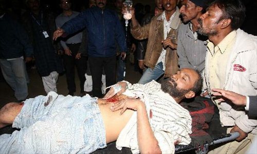 People wheel an injured man at hospital in Pakistan's Karachi on Jan. 1, 2013. At least two people were killed and 35 others injured on Tuesday evening as a bomb went off in a busy area in Karachi. Photo: Xinhua