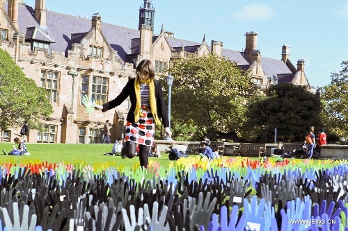 A girl student plants a plastic hand in the large art work of 
