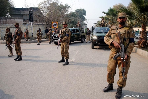 Pakistani soldiers stand guard during a protest attended by villagers from Bara in northwest Pakistan's Peshawar on Jan. 16, 2013. Demonstrators said gunmen wearing military uniforms stormed homes in Bara Tehsil in Khyber Agency, some 30 kilometers from Peshawar, and shot 18 villagers dead in an overnight raid. (Xinhua/Umar Qayyum) 