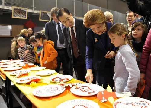 EU commissioner Androulla Vassiliou (2nd R, front) and Chinese ambassador to EU Wu Hailong (3rd R, front) watch plates painted by children during an event to celebrate the Spring Festival at the 4th Brussels European School in Brussels, capital of Belgium, on Feb. 2, 2013. The Chinese embassy in EU and the 4th Brussels European School held an event to introduce Chinese Spring Festival to hundreds of pupils and their parents Saturday.(Xinhua/Ye Pingfan)