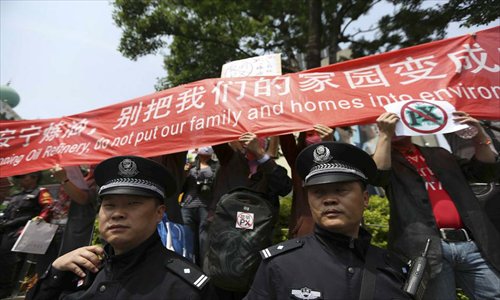 Policemen watch as protestors in Kunming, the capital of Yunnan Province, rally against the planned construction of a China National Petroleum Corporation (CNPC) petrochemical plant on May 4. Nearly 3,000 Kunming residents gathered in the city’s Nanping Square to protest against the CNPC-proposed oil refinery. The protests were conducted without incident. Photo: china.com