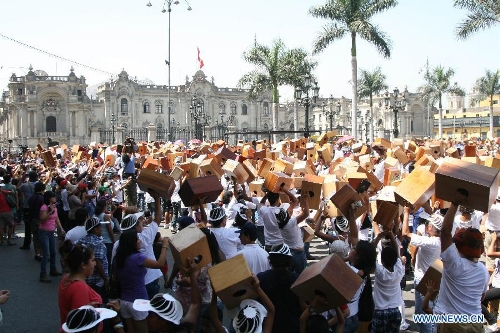 Residents attend the VI Peruvian Cajon International Festival at Plaza de Armas in Lima City, capital of Peru, on April 13, 2013. Over a thousand people gathered here on Saturday to play their Cajones, breaking a Guinness World Record for the world's largest cajon ensemble. (Xinhua/Luis Camacho)