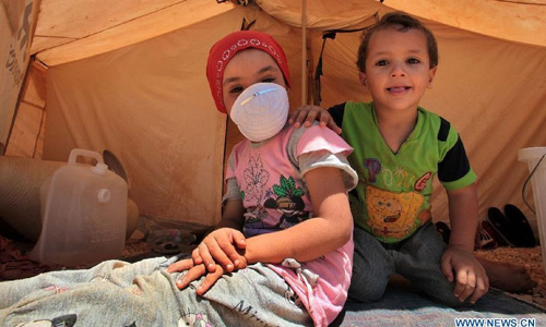 Syrian refugee children are seen at the Zaatari camp for Syrian refugees, 15 kilometres (nine miles) from the kingdom's northern city of Mafraq, near the border with Syria, on August 11, 2012. There are now about 3,000 Syrians taking shelters in the desert Zaatari refugee camp that was opened last month to alleviate the humanitarian crisis. Photo: Xinhua